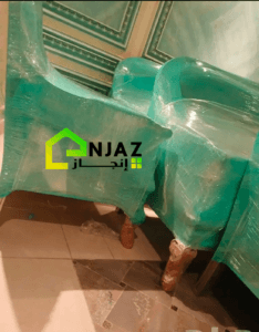 عامل محترف ينفذ عملية تنظيف أثاث باستخدام معدات حديثة لتعقيم الأثاث وإزالة الأوساخ، مع التركيز على الجودة والنظافة لضمان بيئة صحية